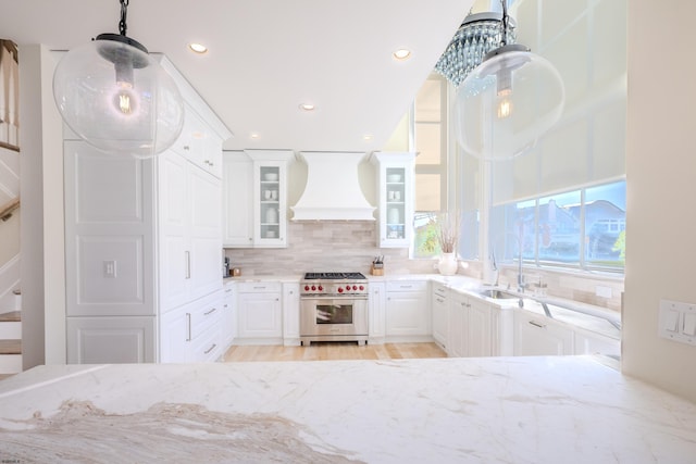 25 S Union Ave, Margate, NJ 08402 - kitchen with high end stainless steel range oven, premium range hood, a sink, backsplash, and light stone countertops