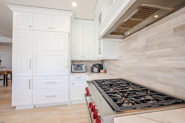 25 S Union Ave, Margate, NJ 08402 - kitchen featuring stainless steel range, premium range hood, backsplash, light stone counters, and glass insert cabinets