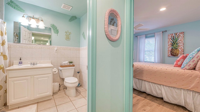 1312 Ocean Ave Unit 1, Ocean City, NJ 08226 - ensuite bathroom with toilet, vanity, ceiling fan, tile walls, and wainscoting