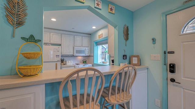 1312 Ocean Ave Unit 1, Ocean City, NJ 08226 - kitchen featuring white appliances, light countertops, backsplash, white cabinets, and recessed lighting