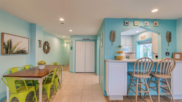 1312 Ocean Ave Unit 1, Ocean City, NJ 08226 - kitchen with white microwave, recessed lighting, white cabinets, and light tile patterned floors