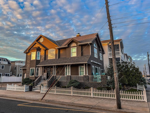 2608 Oberon Ave, Longport, NJ 08403 - view of front of house with covered porch, a fenced front yard, a shingled roof, and a chimney