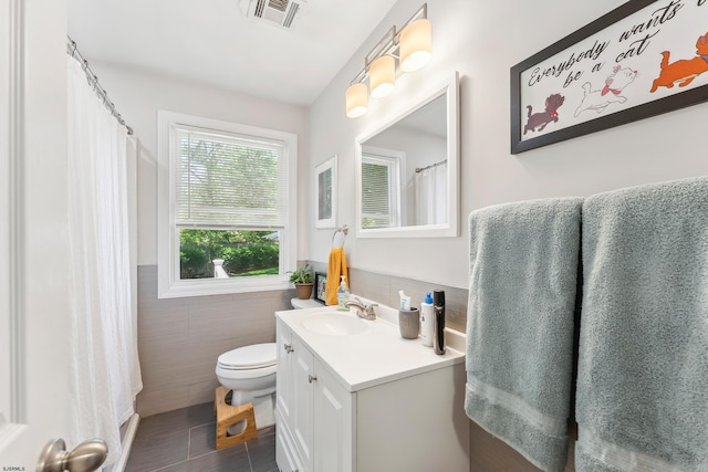 112 Drexel Ave, Egg Harbor Township, NJ 08234 - bathroom with tile walls, tile patterned floors, vanity, toilet, and a wainscoted wall