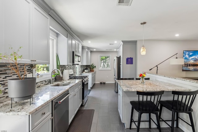 112 Drexel Ave, Egg Harbor Township, NJ 08234 - kitchen with appliances with stainless steel finishes, a sink, decorative backsplash, recessed lighting, and a breakfast bar area