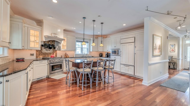 8201 Amherst, Margate, NJ 08401 - kitchen with stainless steel appliances, a kitchen breakfast bar, light wood-style floors, a center island, and backsplash