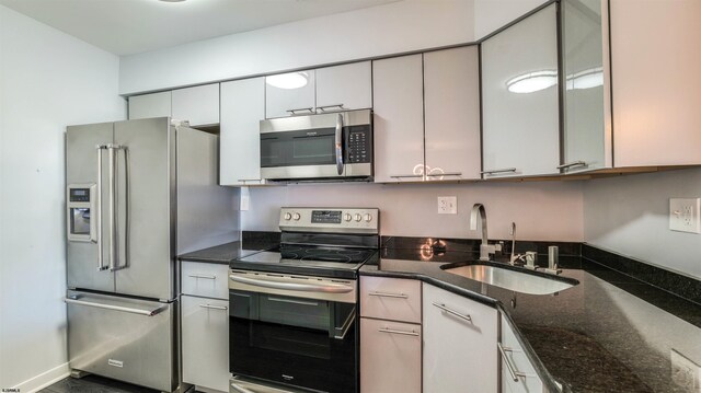 903 Harbour Cv Unit 903, Somers Point, NJ 08244 - kitchen featuring appliances with stainless steel finishes, a sink, dark stone counters, and white cabinetry