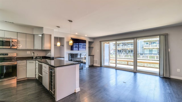 903 Harbour Cv Unit 903, Somers Point, NJ 08244 - kitchen with appliances with stainless steel finishes, dark countertops, a peninsula, baseboards, and dark wood finished floors