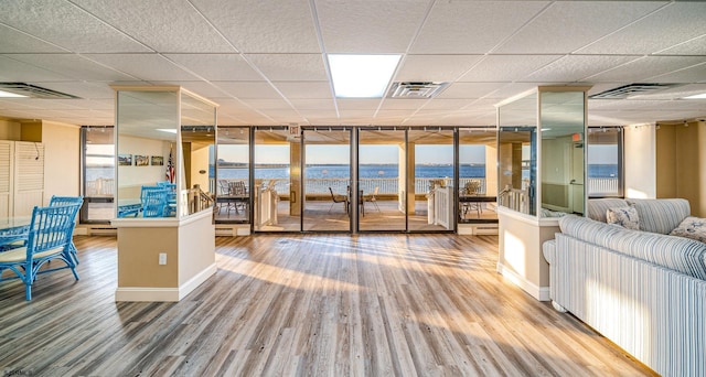 500 Bay Ave Unit 404South, Ocean City, NJ 08226 - living area featuring wood finished floors, a paneled ceiling, a water view, and baseboards