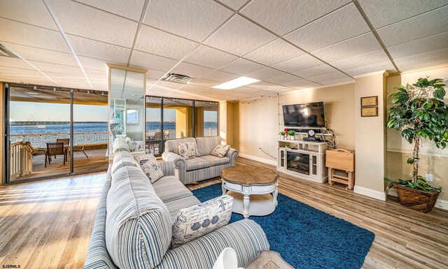 500 Bay Ave Unit 404South, Ocean City, NJ 08226 - living room with wood finished floors, baseboards, a drop ceiling, a glass covered fireplace, and a water view