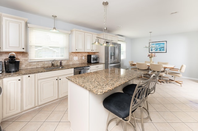 608 Delavan Ave, Margate, NJ 08402 - kitchen featuring a sink, appliances with stainless steel finishes, light tile patterned floors, cream cabinets, and decorative backsplash