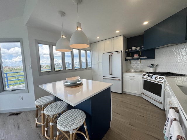 13 Delmar Ln, Brigantine, NJ 08203 - kitchen with white appliances, white cabinetry, a kitchen island, wood finished floors, and decorative backsplash