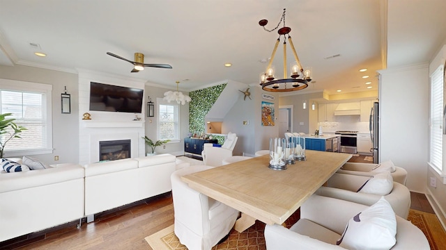 305 15th St, Ocean City, NJ 08226 - dining area featuring a chandelier, wood finished floors, a large fireplace, recessed lighting, and crown molding