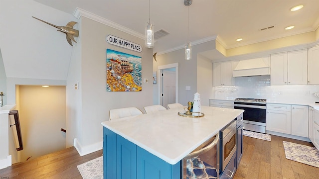 305 15th St, Ocean City, NJ 08226 - kitchen featuring appliances with stainless steel finishes, wood finished floors, premium range hood, crown molding, and white cabinets