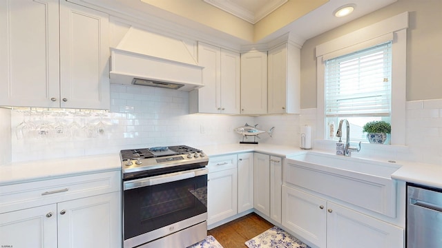 305 15th St, Ocean City, NJ 08226 - kitchen featuring stainless steel appliances, crown molding, light countertops, custom exhaust hood, and white cabinetry