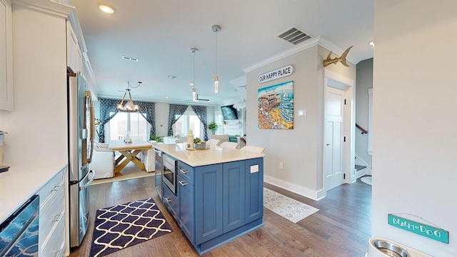 305 15th St, Ocean City, NJ 08226 - kitchen with blue cabinetry, dark wood-style floors, stainless steel appliances, light countertops, and ornamental molding