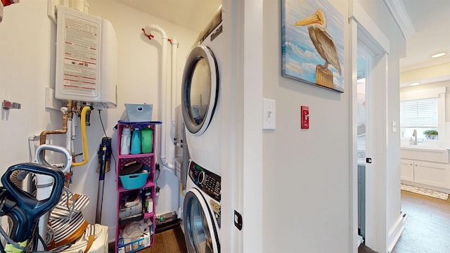 305 15th St, Ocean City, NJ 08226 - laundry room with stacked washer / dryer, tankless water heater, crown molding, recessed lighting, and wood finished floors