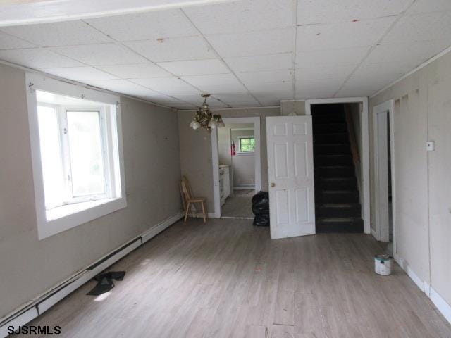 1412 W Cleveland Ave, Egg Harbor City, NJ 08215 - empty room with stairway, light wood-style floors, a drop ceiling, baseboard heating, and a chandelier