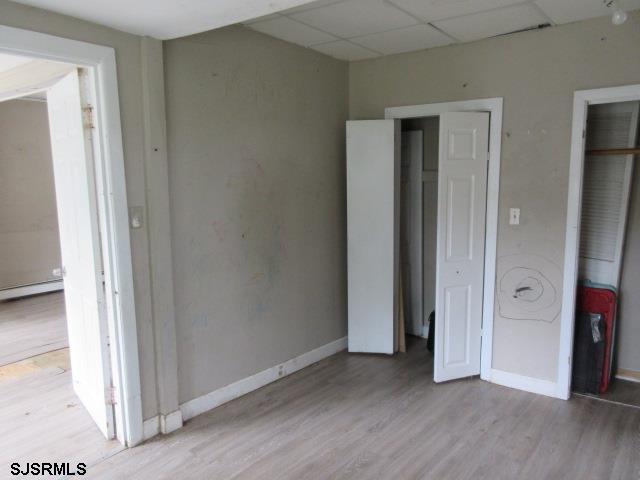 1412 W Cleveland Ave, Egg Harbor City, NJ 08215 - unfurnished bedroom with wood finished floors, a paneled ceiling, and baseboards