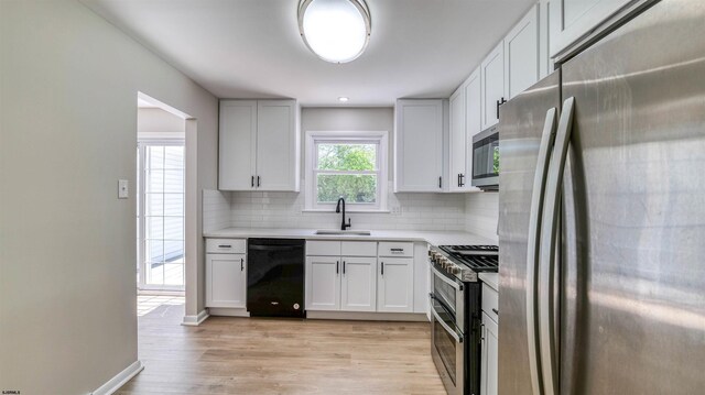 11 Carann Ln, Egg Harbor Township, NJ 08234 - kitchen featuring appliances with stainless steel finishes, a sink, backsplash, light wood finished floors, and light countertops