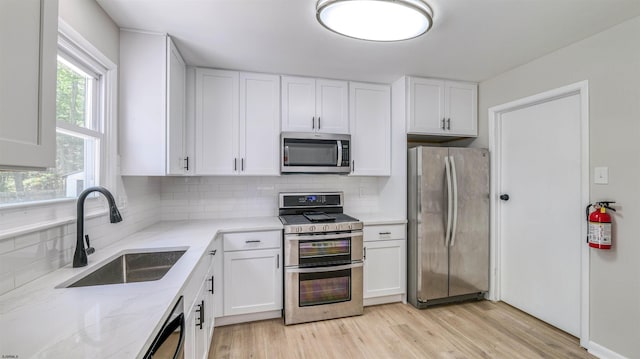 11 Carann Ln, Egg Harbor Township, NJ 08234 - kitchen featuring stainless steel appliances, a sink, decorative backsplash, white cabinetry, and light stone countertops
