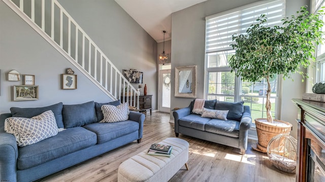 521 Saratoga Pl, Smithville, NJ 08234 - living room featuring a high ceiling, a chandelier, wood finished floors, a fireplace, and stairway