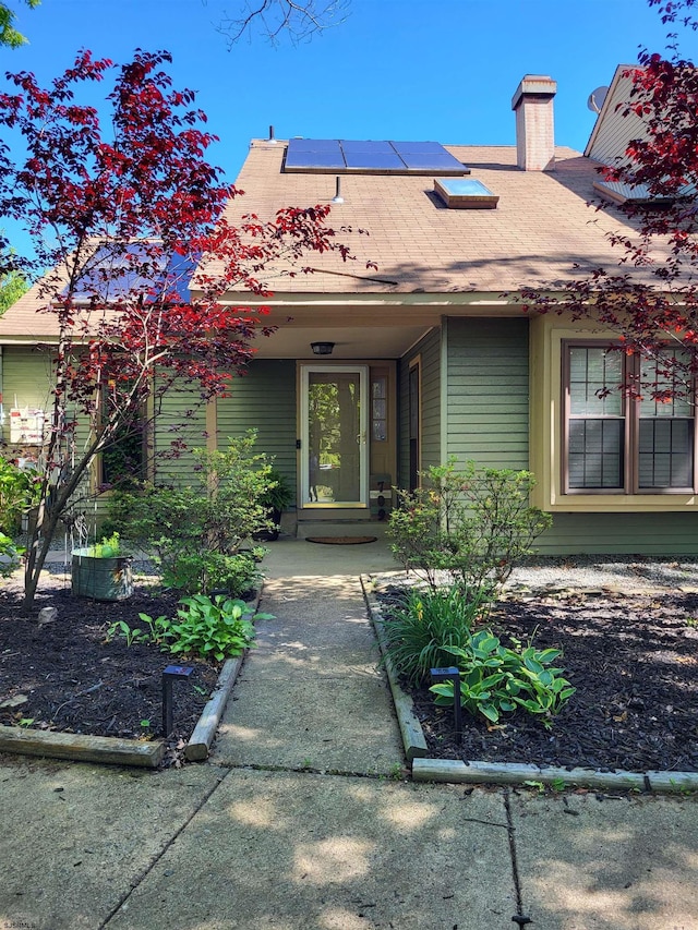 709 E Cooper Ferry Ct Unit 709, Galloway Township, NJ 08205 - property entrance with roof mounted solar panels, a chimney, and a shingled roof