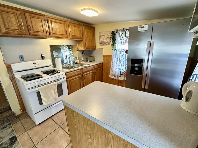 311 N 7th St, Millville, NJ 08332 - kitchen featuring white gas stove, stainless steel fridge with ice dispenser, a sink, light countertops, and brown cabinetry