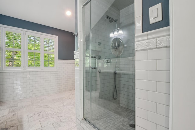 515 Bella Ct, Galloway Township, NJ 08205 - bathroom featuring a shower stall, marble look tiles, tile walls, and a wainscoted wall