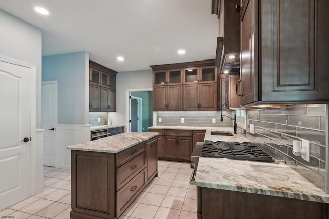 515 Bella Ct, Galloway Township, NJ 08205 - kitchen featuring backsplash, a sink, dark brown cabinetry, light tile patterned floors, and glass insert cabinets