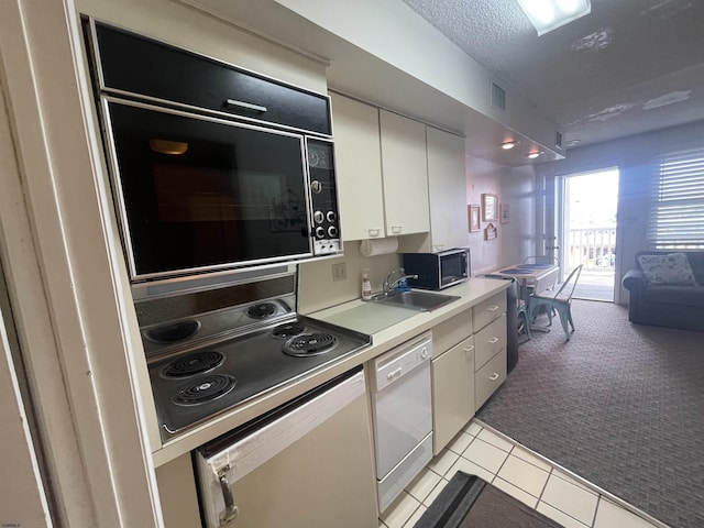 853-71 Plymouth Pl Unit 13, Ocean City, NJ 08226 - kitchen featuring white dishwasher, light colored carpet, black microwave, stainless steel microwave, and a sink