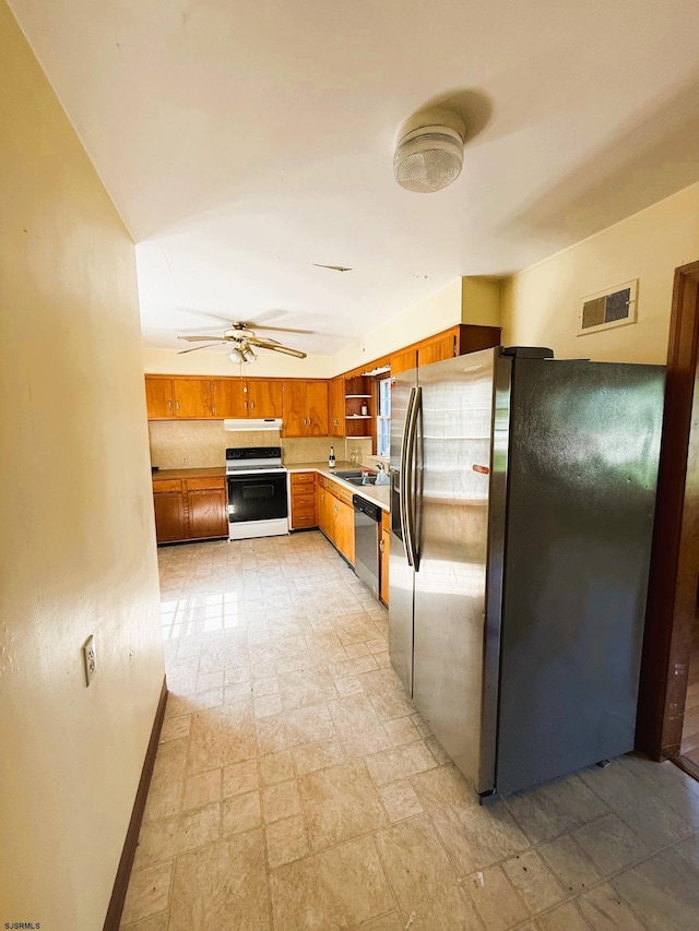 4 E Finley Rd, Upper Deerfield Township, NJ 08302 - kitchen featuring appliances with stainless steel finishes, under cabinet range hood, brown cabinets, and light stone finish floors