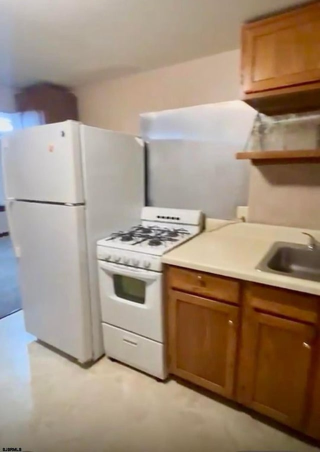 220 Seaside Ave, Atlantic City, NJ 08401 - kitchen with white appliances, brown cabinets, a sink, and light countertops