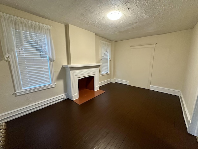 220 Seaside Ave, Atlantic City, NJ 08401 - unfurnished living room featuring dark wood finished floors, a fireplace with flush hearth, a textured ceiling, and baseboards