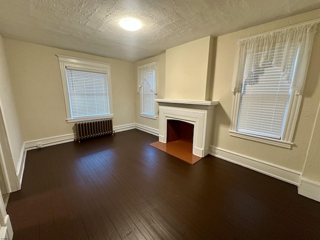 220 Seaside Ave, Atlantic City, NJ 08401 - unfurnished living room with radiator heating unit, a fireplace with flush hearth, baseboards, dark wood-style floors, and a textured ceiling