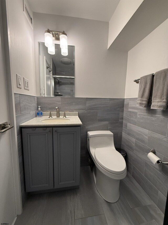 101 S Raleigh Ave Unit 733, Atlantic City, NJ 08401 - bathroom featuring tile walls, vanity, toilet, a shower, and a wainscoted wall