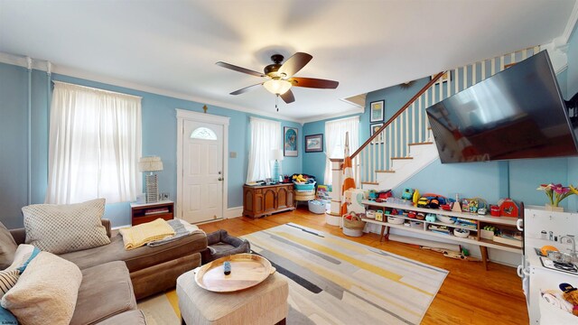 27 School St, Absecon, NJ 08201 - living area with healthy amount of natural light, wood finished floors, ceiling fan, stairway, and crown molding