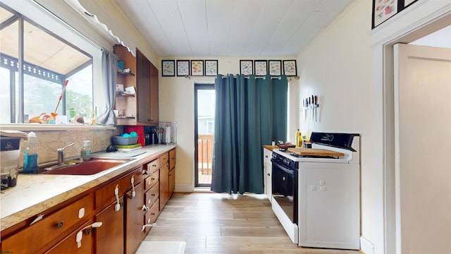 27 School St, Absecon, NJ 08201 - kitchen with white gas range oven, a sink, brown cabinets, light wood-style floors, and light countertops