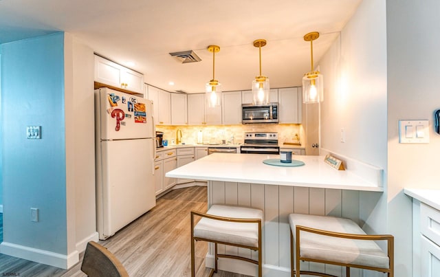 500 Bay Ave Unit 607S, Ocean City, NJ 08226 - kitchen with appliances with stainless steel finishes, a peninsula, light wood finished floors, a kitchen breakfast bar, and tasteful backsplash