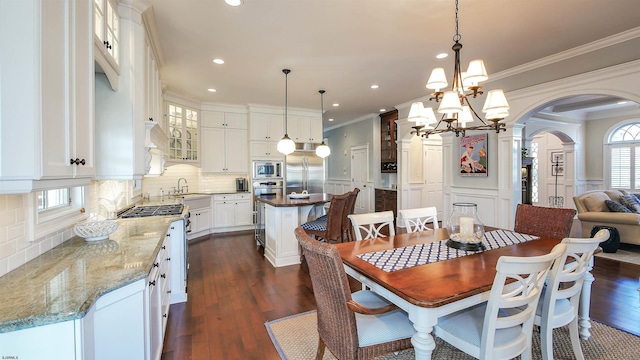 8904 Ventnor Ave, Margate, NJ 08402 - dining area with arched walkways, crown molding, a chandelier, recessed lighting, and dark wood-type flooring