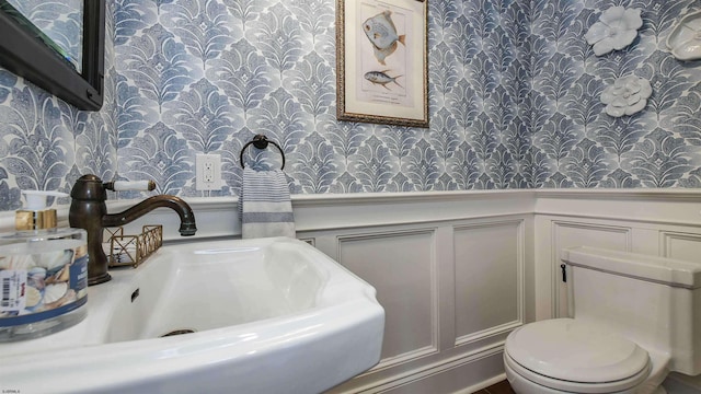 8904 Ventnor Ave, Margate, NJ 08402 - half bathroom with wallpapered walls, a sink, wainscoting, a decorative wall, and toilet