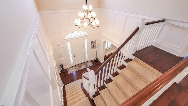 8904 Ventnor Ave, Margate, NJ 08402 - foyer featuring a decorative wall, dark wood-style floors, a chandelier, stairs, and a wainscoted wall