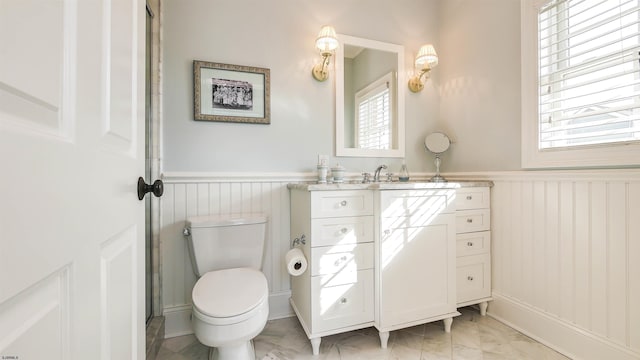 8904 Ventnor Ave, Margate, NJ 08402 - bathroom with wainscoting, marble look tile flooring, vanity, toilet, and a decorative wall