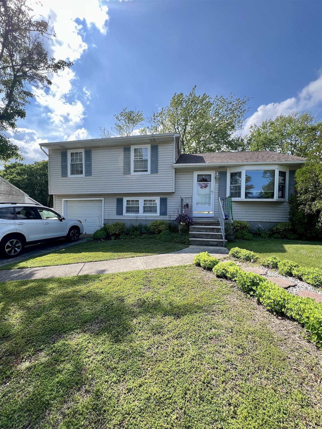 61 Bucknell Rd, Somers Point, NJ 08244 - tri-level home featuring a garage and a front lawn