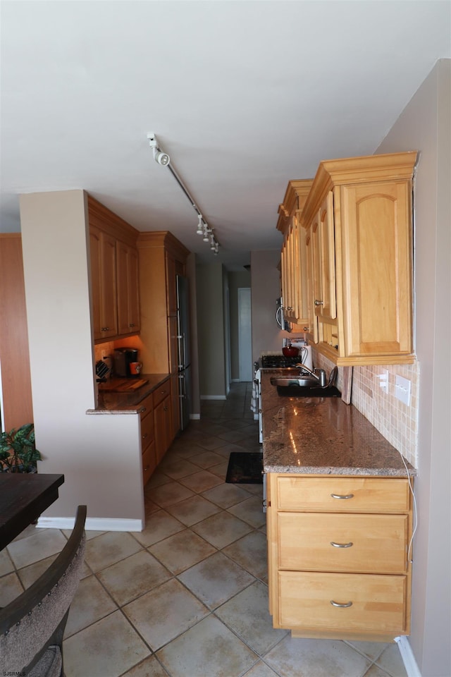6101 Monmouth Ave Unit 201, Ventnor, NJ 08406 - kitchen featuring backsplash, light tile patterned floors, dark stone counters, baseboards, and freestanding refrigerator