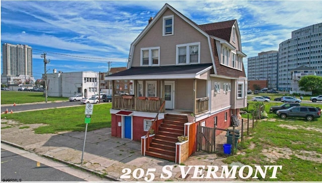 205 S Vermont Ave, Atlantic City, NJ 08401 - colonial inspired home with a gambrel roof, a porch, stairway, and a front lawn