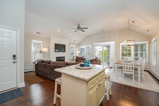 1525 Asbury Ave Unit B, Ocean City, NJ 08226 - kitchen with cream cabinetry, vaulted ceiling, a breakfast bar, a large fireplace, and dark wood-type flooring