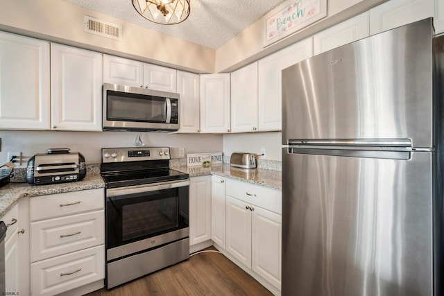 4220 Atlantic-Brigantine Blvd Unit 204A, Brigantine, NJ 08203 - kitchen featuring appliances with stainless steel finishes, white cabinets, a textured ceiling, dark wood finished floors, and light stone counters