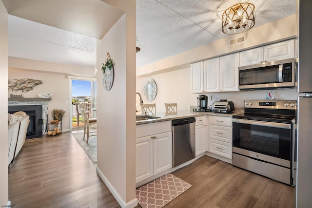 4220 Atlantic-Brigantine Blvd Unit 204A, Brigantine, NJ 08203 - kitchen with stainless steel appliances, wood finished floors, a textured ceiling, and white cabinetry