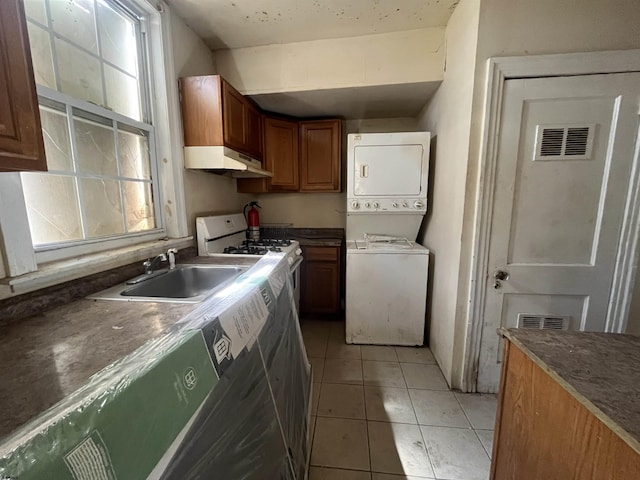 12 Belle Haven Ct, Atlantic City, NJ 08401 - kitchen with estacked washer and dryer, white gas range oven, under cabinet range hood, a sink, and light tile patterned floors
