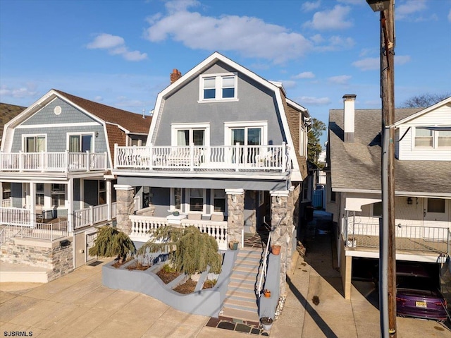 7 N Surrey Ave, Ventnor, NJ 08406 - back of house with a gambrel roof, a chimney, stone siding, and stairway